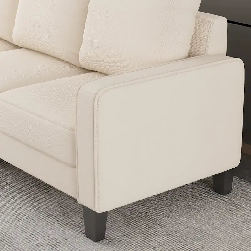 Canapé en tissu beige avec accoudoirs carrés et dossier capitonné